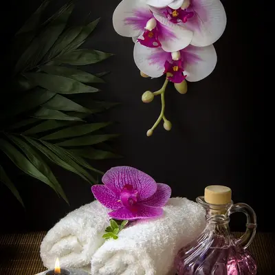 Orchid, rolled towel and massage oil