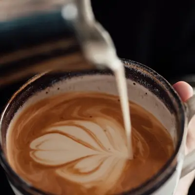 Latte with leaf art in a glass cup